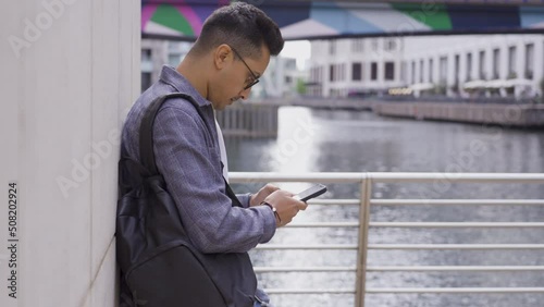 Tracking Shot of Young Man Texting On Smartphone photo