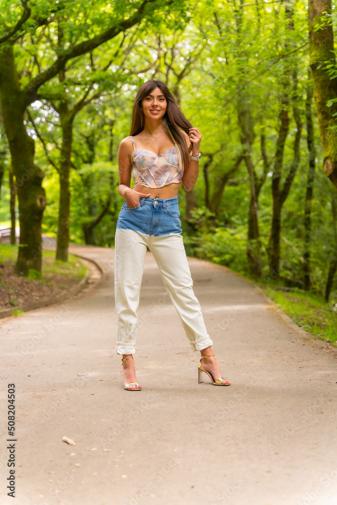 Portrait of a Caucasian girl on a path in a city park, fashionably posed in nature Portrait of a Caucasian girl on a path in a city park, fashionably posed in nature