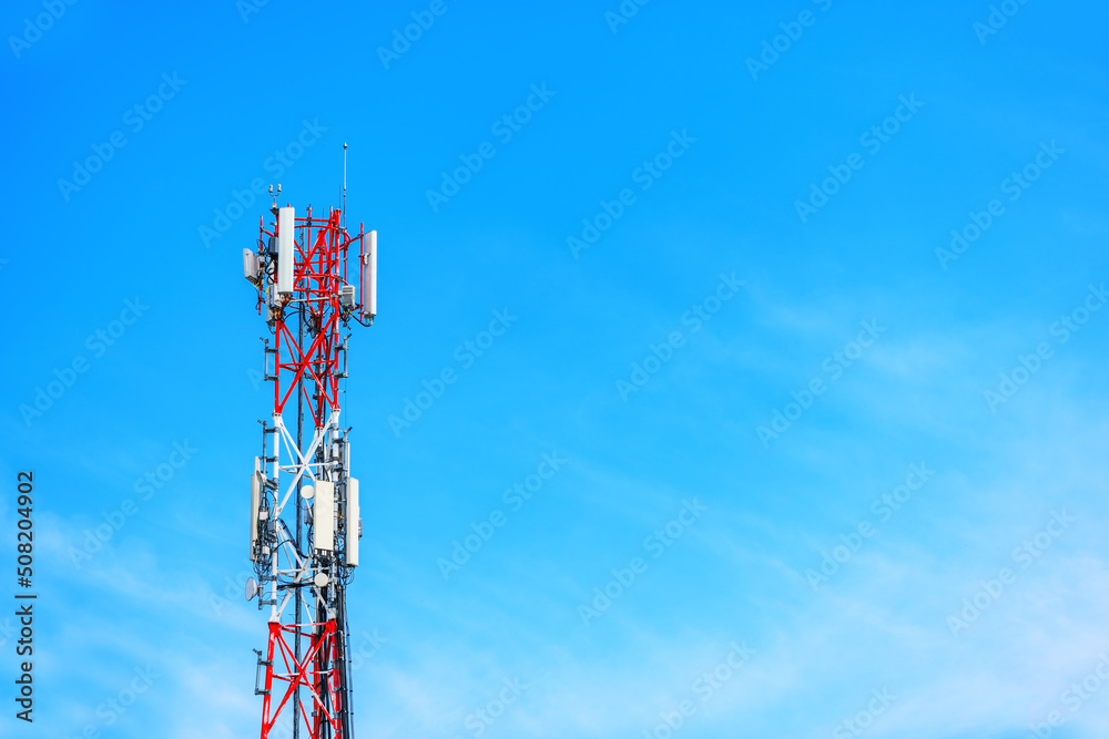 Telecommunication tower with signal repeater antennas against blue sky