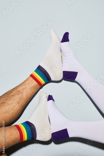 Minimal shot of playful young couple wearing socks feet up, copy space