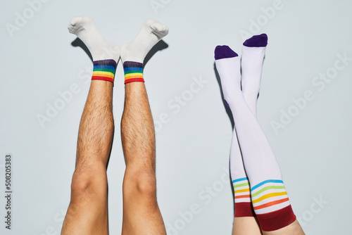 Cuadro en lienzo Minimal shot of playful young couple wearing socks with rainbow symbols feet up
