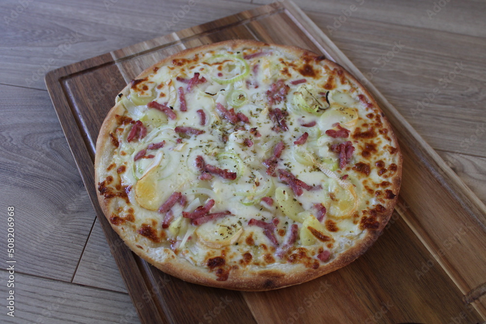 Pizza tartiflette sur plateau en bois, lardons, pommes de terre, oignons,  reblochon Stock Photo | Adobe Stock