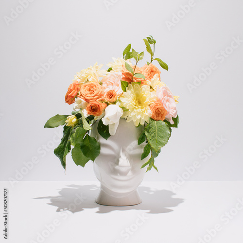 Wallpaper Mural Fresh bunch of colorful flowers in human head shaped vase on grey background. Creativity, nature, ecology and summertime concept. Torontodigital.ca
