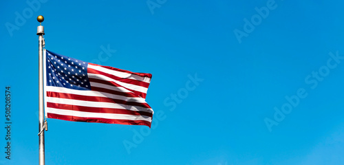 Flag of the USA against blue sky, long panoramic picture with space for text