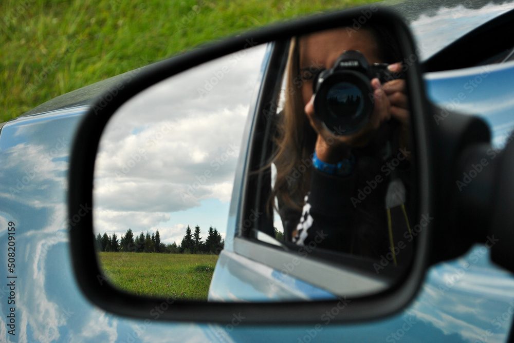traveling photographer in the rearview mirror in nature