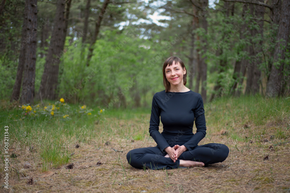 Woman in sports overalls sitting in the forest Woman in sports overalls sitting in the forest