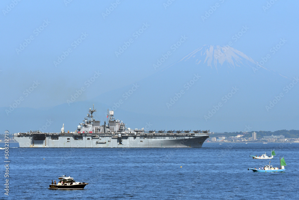 United States Navy amphibious assault ship USS Tripoli sailing in Tokyo Bay with Mt. Fuji in the background.