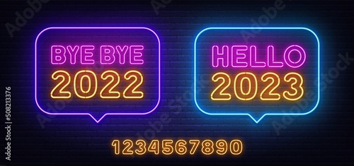 Bye bye 2022 and Hello 2023 neon sign in the speech bubble on brick wall background.
