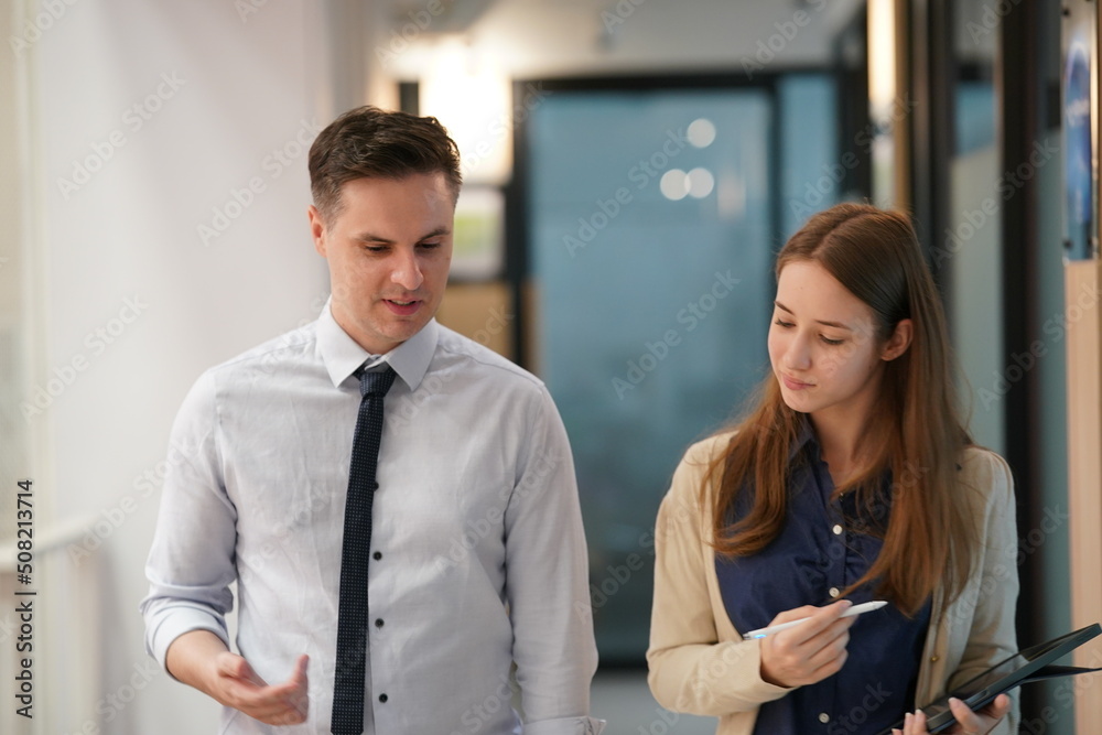 Young man consulting his business partner at meeting in office Young man consulting his business partner at meeting in office