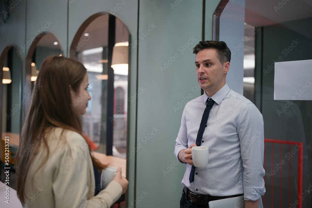 Young man consulting his business partner at meeting in office Young man consulting his business partner at meeting in office