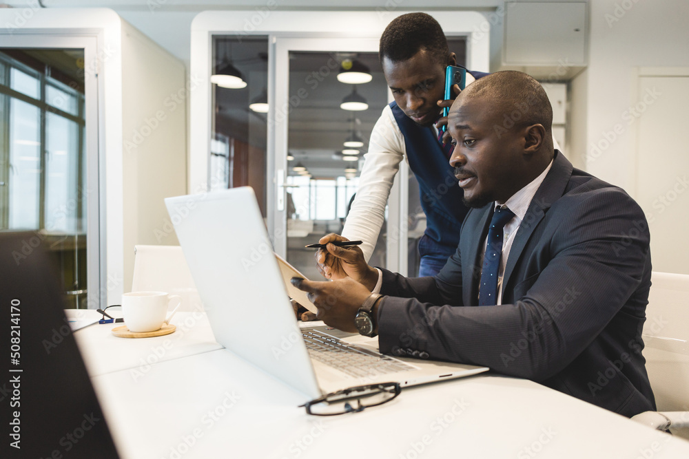 Two African American business partners are working on a laptop together on a common project. Coworking, social contacts and remote networking Two African American business partners are working on a laptop together on a common project. Coworking, social contacts and remote networking