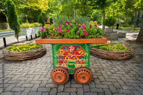 Vendor wooden cart used as flower pot at the entrance of Laleh park in Tehran, Iran photo