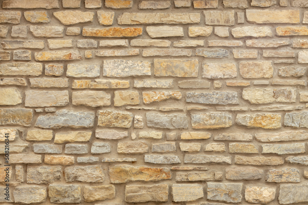 Solid yellow and beige stone wall. Stone background.