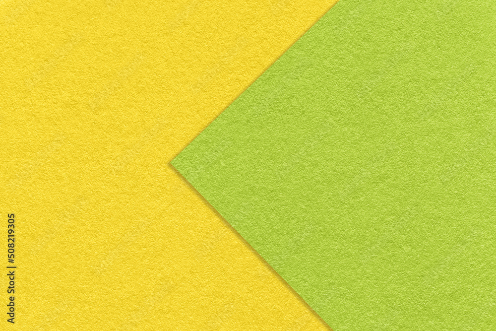 Texture of green and yellow paper background, half two colors, macro. Structure of dense craft cardboard. Texture of green and yellow paper background, half two colors, macro. Structure of dense craft cardboard.