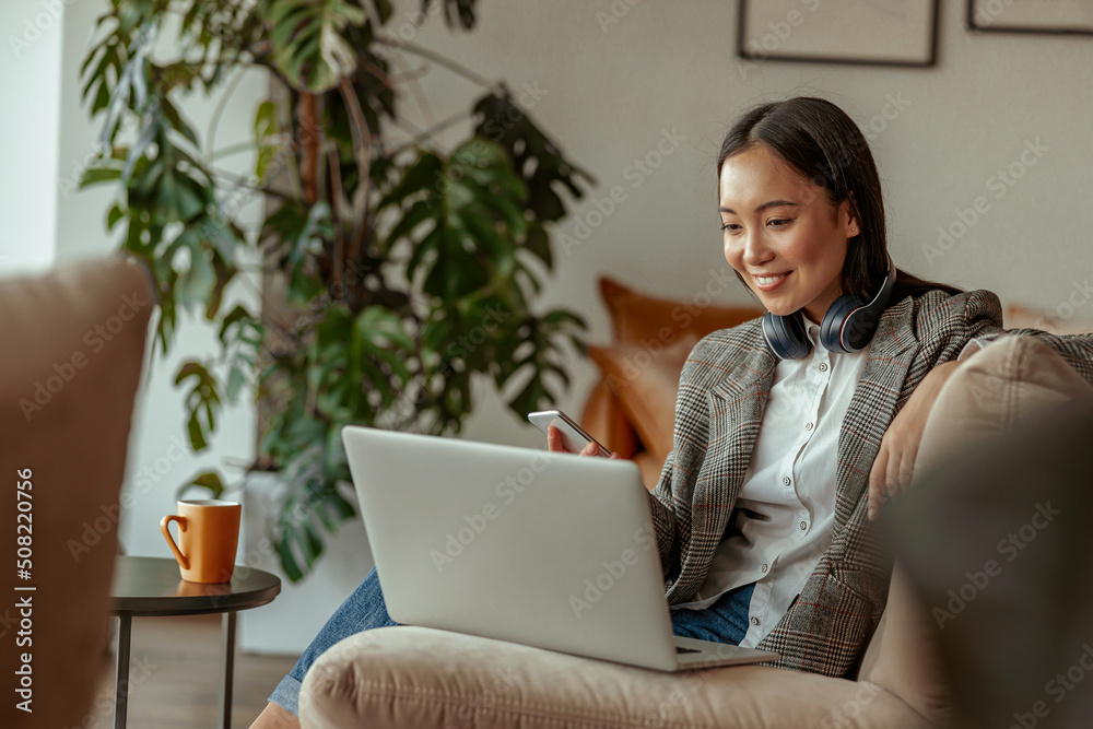 Smiling asian business woman working laptop sitting in cozy cafe. High quality photo Smiling asian business woman working laptop sitting in cozy cafe. High quality photo