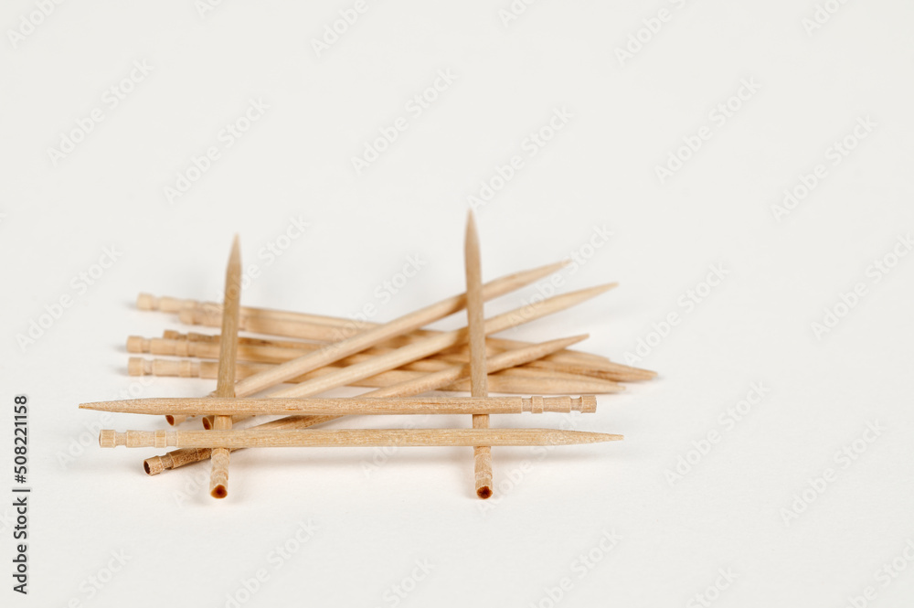 Closeup view of a pile of wooden toothpicks on a white bsckground Closeup view of a pile of wooden toothpicks on a white bsckground