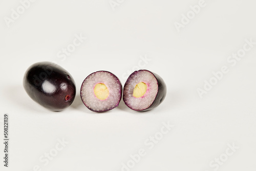 Whole and cut Jambolan plum or Java Plum or Jamun fruit on a white background