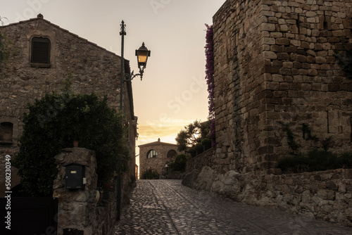 stone street in the medieval town of pals on a summer day at sunset