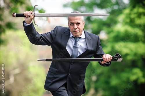 Handsome businessman in suit with sword. Corporate and money security