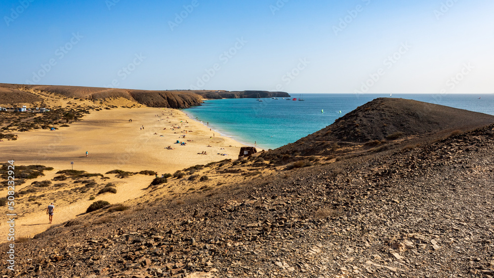 View from hillside over Playa Mujeres, Playa Blanca, Yaiza, Lanzarote, Las  Palmas, Islas Canarias, Spain, Europe. Golden sand washed by the clear  turquoise waters of the Atlantic Ocean. Stock Photo | Adobe