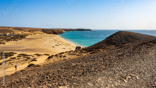 View from hillside over Playa Mujeres, Playa Blanca, Yaiza, Lanzarote, Las Palmas, Islas Canarias, Spain, Europe. Golden sand washed by the clear turquoise waters of the Atlantic Ocean. photo