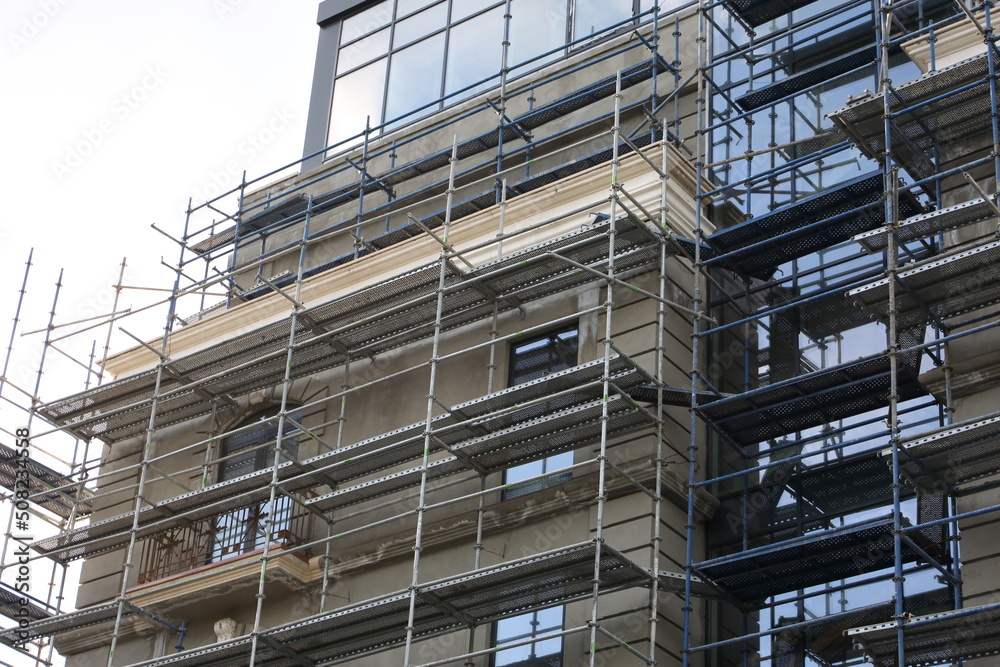Scaffolding. Repair of the facade of the building at a high altitude. Construction work on building a house Scaffolding. Repair of the facade of the building at a high altitude. Construction work on building a house