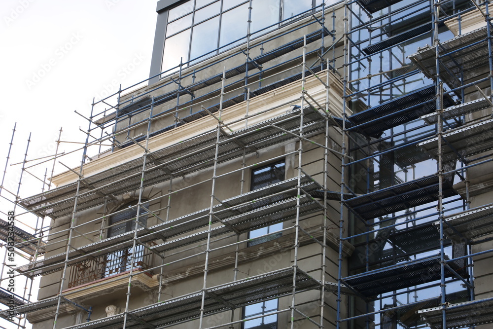 Scaffolding. Repair of the facade of the building at a high altitude. Construction work on building a house