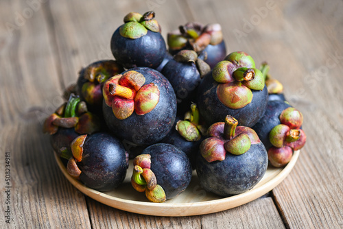 Mangosteen on wooden plate background, fresh ripe mangosteen from tree at tropical fruit Thailand in summer