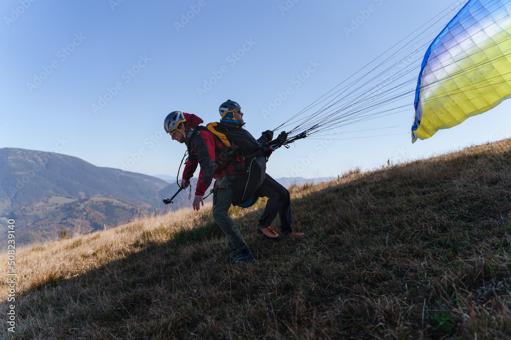 Paragliders preparing for the flight in mountain. Extreme sports activity.