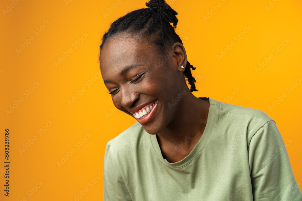Portrait of beautiful positive african american woman in yellow studio