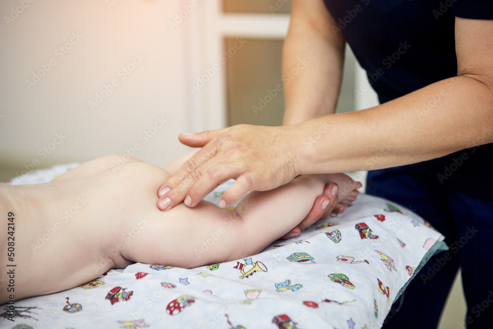 Close up of massage therapist working with cute baby child in medical center Close up of massage therapist working with cute baby child in medical center