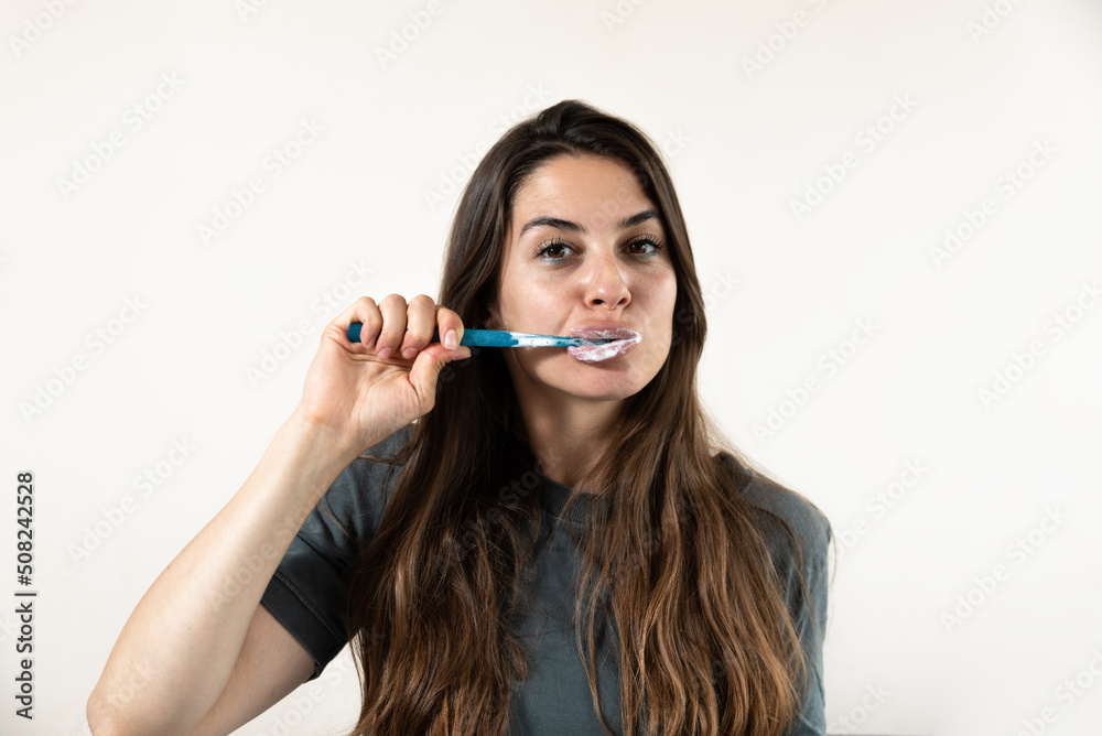 Young beautiful woman brushes her teeth with a toothbrush in the morning. Self loved female preparing and doing morning routine self hygiene before she go to the work. Young beautiful woman brushes her teeth with a toothbrush in the morning. Self loved female preparing and doing morning routine self hygiene before she go to the work.
