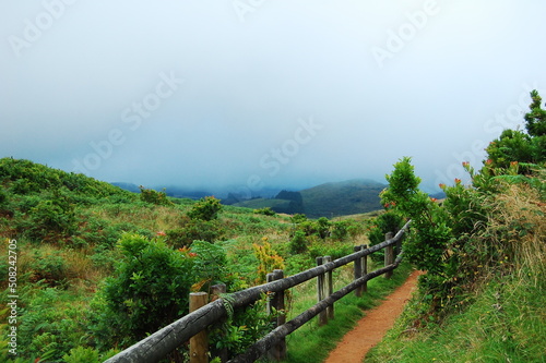 Road in a volcanic crater with a wooden railing in the Azores