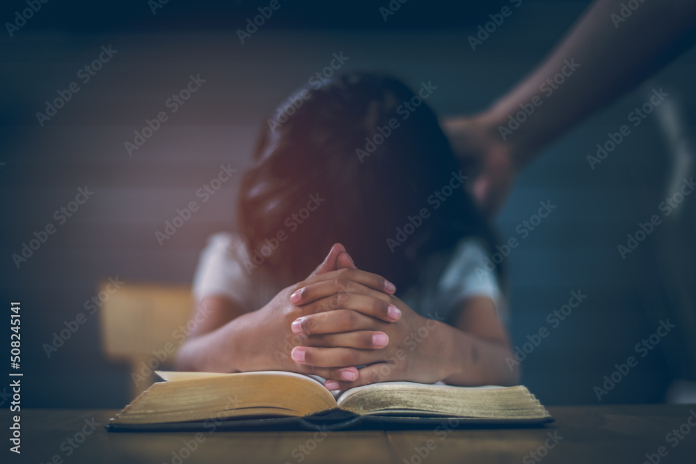 Foto de Asian Christian girl Both hands join together to pray and seek the  blessings of God. She was reading the Bible and sharing the gospel in  church. Concepts of Faith, Spirituality