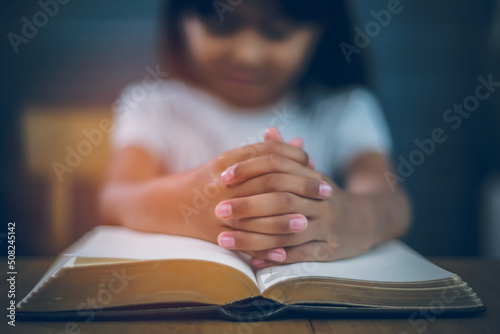 Asian Christian girl Both hands join together to pray and seek the blessings of God. She was reading the Bible and sharing the gospel in church. Concepts of Faith, Spirituality and Religion.