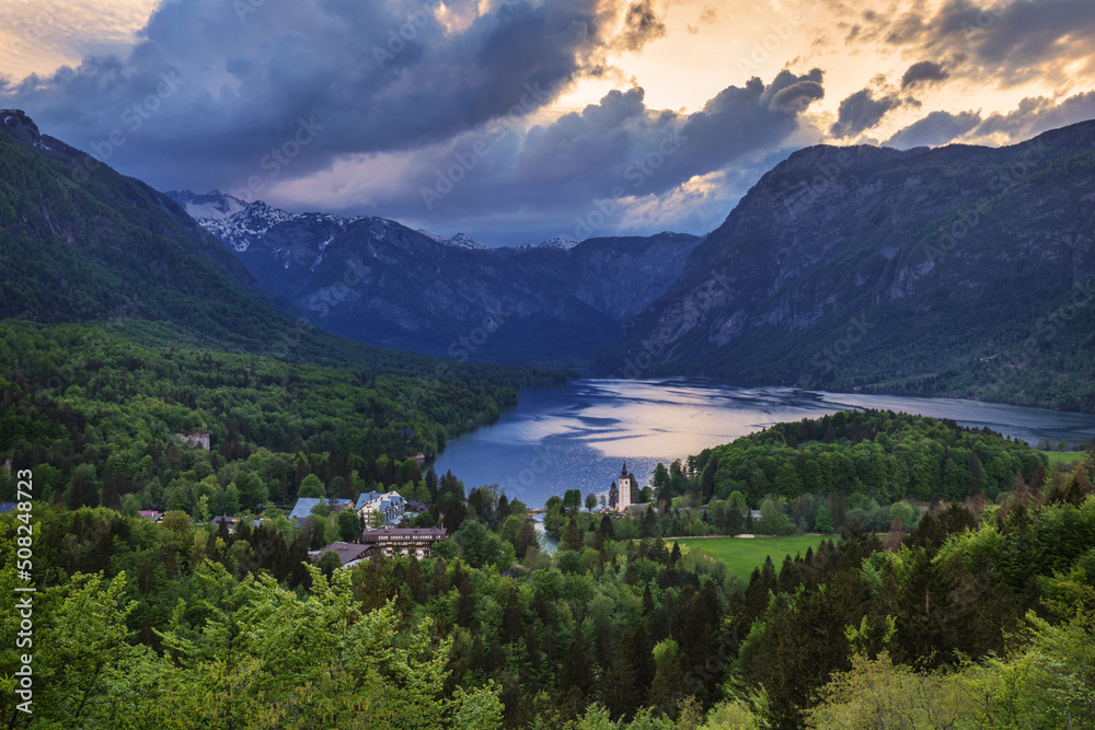 Aerial view of Bohinj lake in Julian Alps. Breathtaking view of the famous Bohinj lake from above. Beautiful view of the Triglav national park and the church of St John the Baptist. Slovenia, Europe