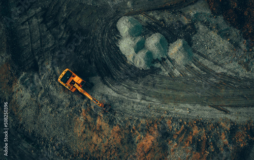 bright excavator at work on a dark background view from a drone