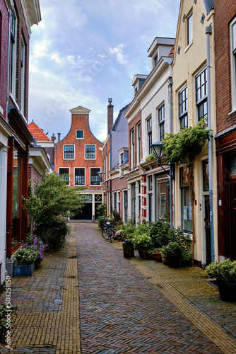 A peaceful cobbled alley with bicycles parked outside traditional houses. Springtime in Haarlem, Netherlands.