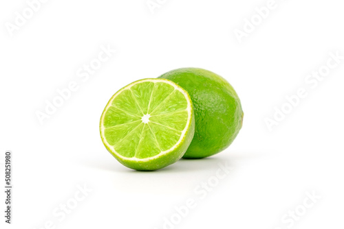 Fresh and ripe green lime whole and cut in half, vitamin rich fruit, exotic fruit isolated