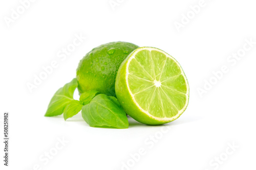 Fresh and ripe green lime whole and cut in half, vitamin rich fruit, exotic fruit isolated