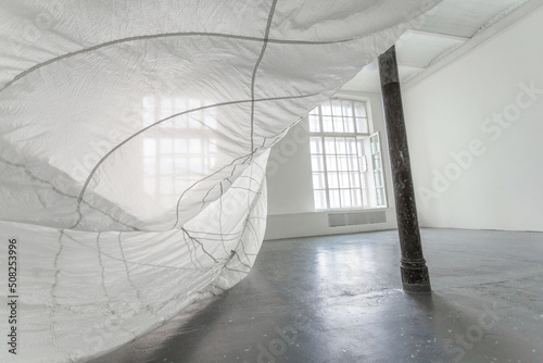 Part of the white interior with black column and white parachute waving on the air.