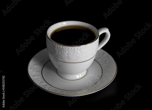 Porcelain cup of tea with tea isolated on black background  selective focus