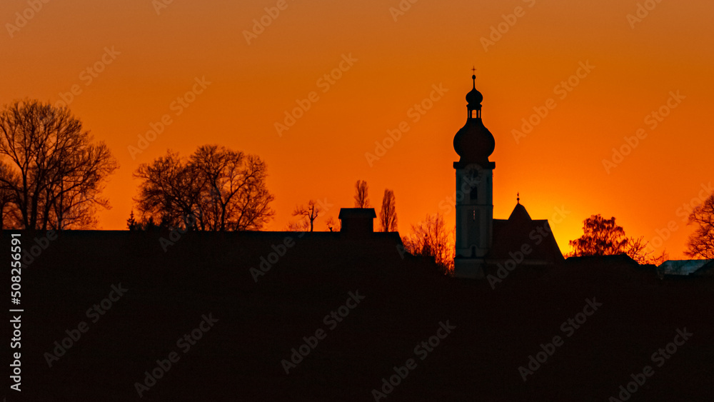 Beautiful sunset with a church silhouette near Buchhofen, Bavaria, Germany