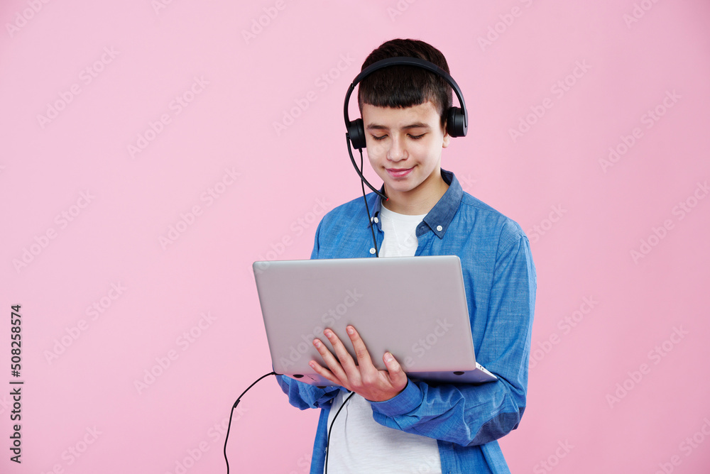 Young teenage boy using his laptop, working on his school work or taking an online class Young teenage boy using his laptop, working on his school work or taking an online class
