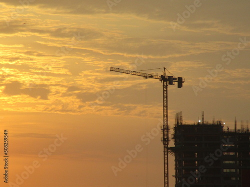 Grúa y edificio en construcción al atardecer photo