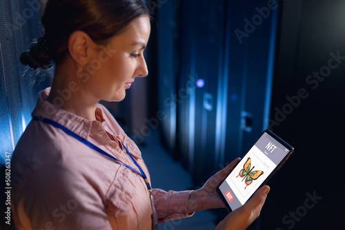 Caucasian mid adult businesswoman looking at butterfly image for sale on website over digital tablet