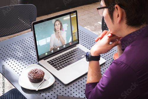 Asian businessman discussing strategies with caucasian businesswoman through online meeting