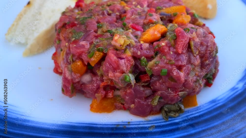 Picking up steak tartare with a piece of toasted bread, eating a traditional french dish in a restaurant, 4K shot Picking up steak tartare with a piece of toasted bread, eating a traditional french dish in a restaurant, 4K shot