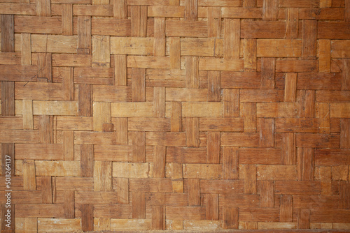 The background wall of the house is made of woven bamboo.