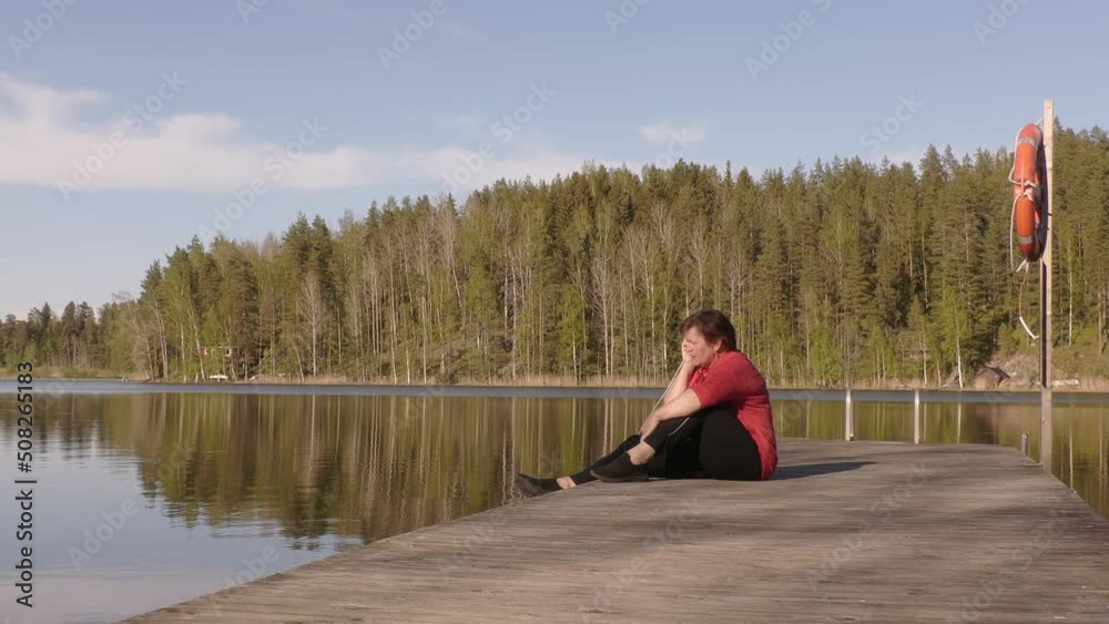 Awesome shot of a middle aged lady on a floating swimming bridge on a sunny day. Talking on her phone and enjoying the weather. Awesome shot of a middle aged lady on a floating swimming bridge on a sunny day. Talking on her phone and enjoying the weather.